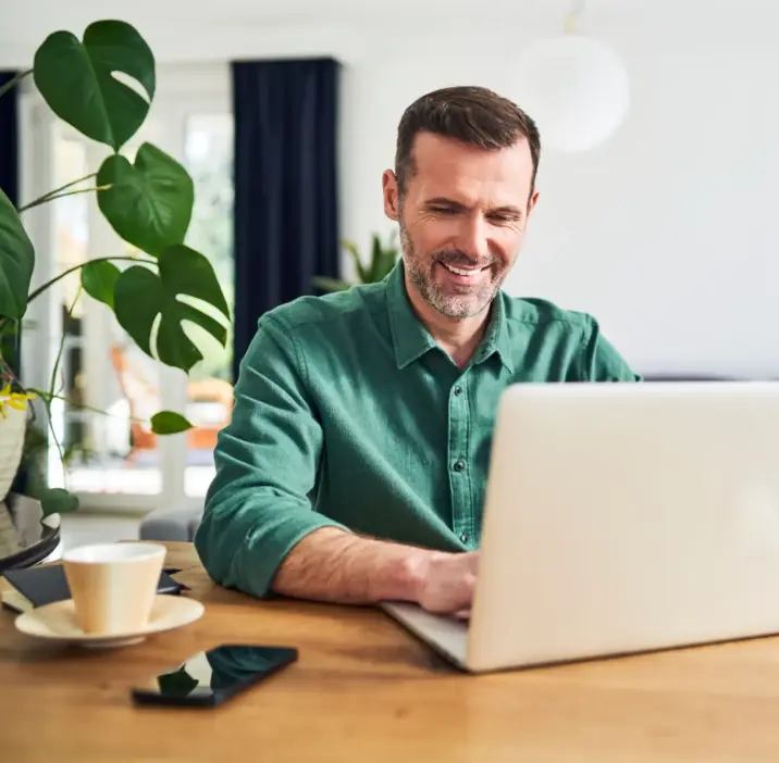 Klient po zakupie usługi przy laptopie przy stole